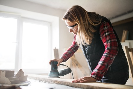 Young woman worker in the carpenter workroom.の写真素材