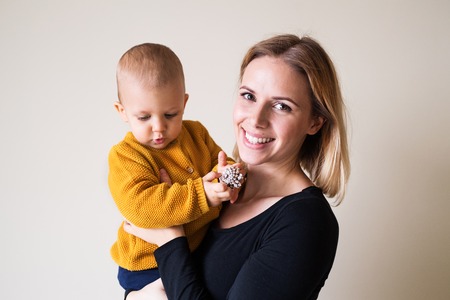 Young woman holding a toddler boy.