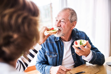 Senior couple eating breakfast at home.の写真素材