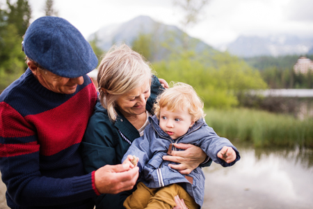 Senior couple with little boy at the lake.