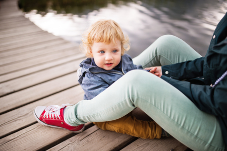 Senior woman with little boy at the lake.の写真素材