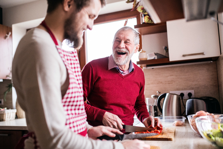 Hipster son with his senior father cooking in the kitchen.の写真素材