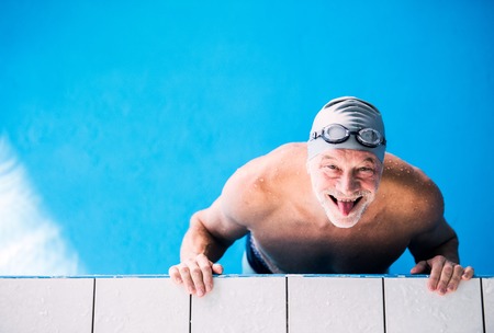 Senior man in an indoor swimming pool.の写真素材