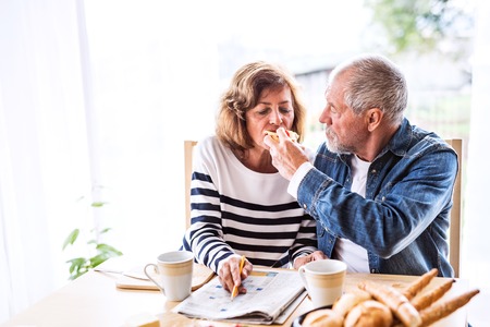 Senior couple eating breakfast at home.の写真素材