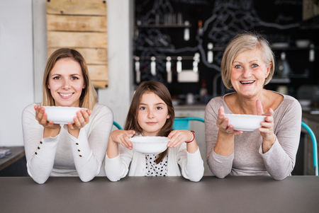 A small girl with mother and grandmother at home.の写真素材