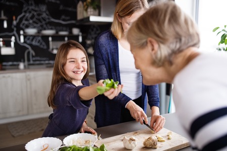 A small girl with mother and grandmother at home.