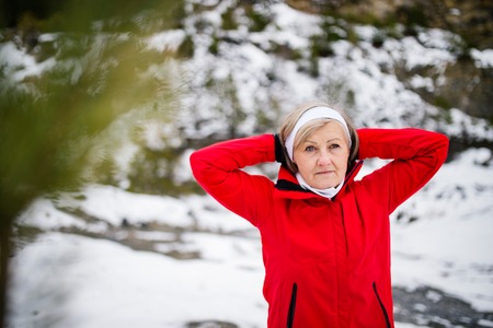 Senior woman jogging in winter nature.の写真素材