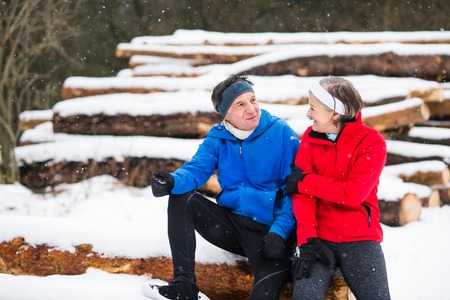 Senior couple jogging in winter nature.の写真素材