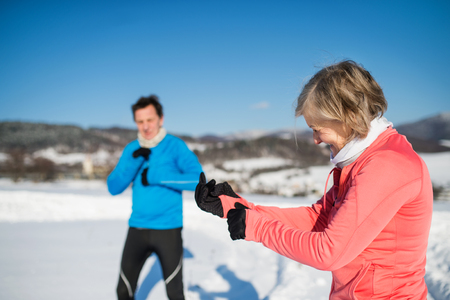 Senior couple jogging in winter nature.の写真素材