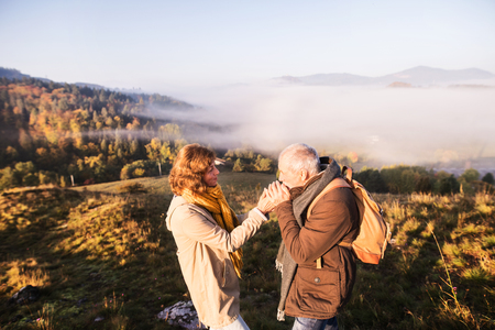 Senior couple on a walk in an autumn nature.の写真素材