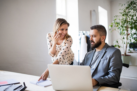Two business people with smartphone in the office.の写真素材
