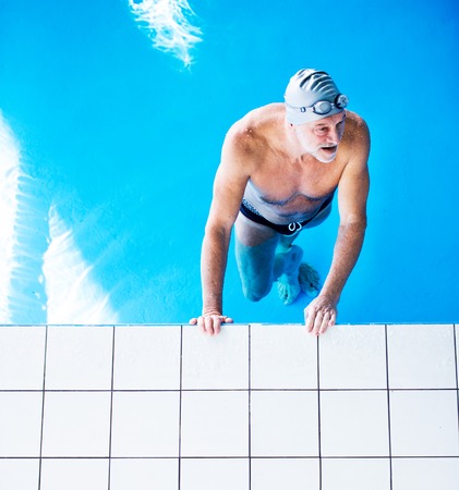 Senior man in an indoor swimming pool.
