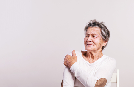 Studio portrait of a senior woman in pain.の写真素材
