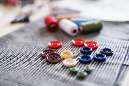 Buttons and thread bobbins on a fabric.の写真素材