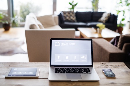 A laptop, tablet and telephone with smart home screen.