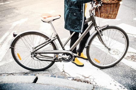 Young woman with bicycle in sunny spring town.の写真素材