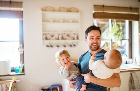 Father with two toddlers at home.の写真素材