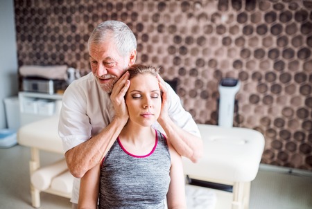 Senior male physiotherapist working with a female patient.の写真素材