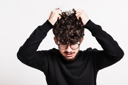 Portrait of an unhappy young man in a studio.の写真素材