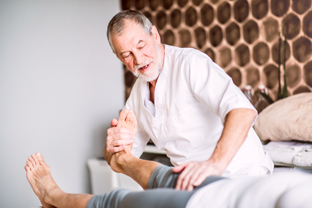 Senior physiotherapist working with a female patient.