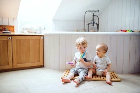 Two toddler children brushing teeth in the bathroom at home.の写真素材