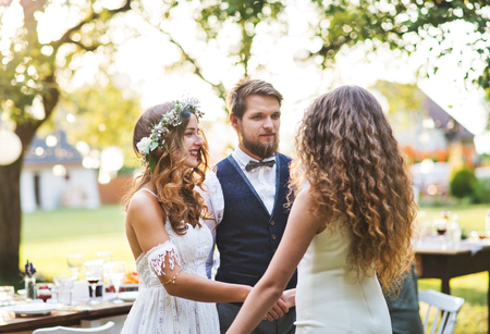 Young girl congratulating bride and groom at wedding reception in the backyard.の写真素材