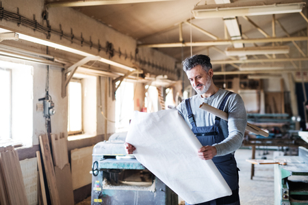 Portrait of a man worker in the carpentry workshop.の写真素材