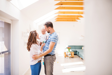 Young family with a baby boy at home, standing.の写真素材