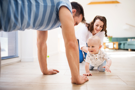 Young family with a baby boy at home, having fun.の写真素材