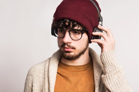 Portrait of a young man with headphones in a studio.