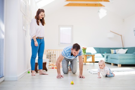Young family playing with a baby boy at home.の写真素材