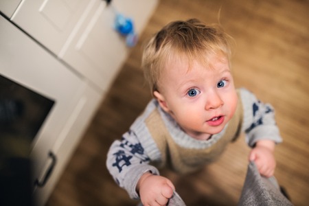 Top view of a toddler boy looking up at home. Close up.