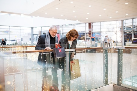 Happy senior couple doing Christmas shopping together.の写真素材