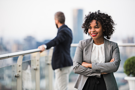 A portrait of a businesswoman standing on a terrace, arms crossed.の写真素材