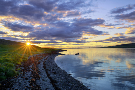 A beach and sea landscape in Iceland at sunset.