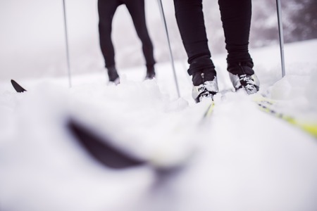 An unrecognizable couple cross-country skiing in winter.の写真素材