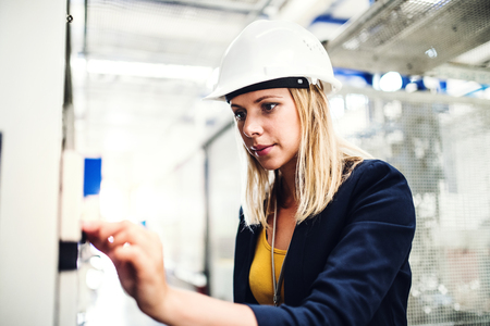 A portrait of an industrial woman engineer in a factory checking something.の写真素材