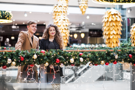 A young couple standing in shopping center at Christmas. Copy space.の写真素材