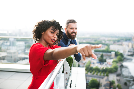 A portrait of two businesspeople standing against London view panorama.の写真素材