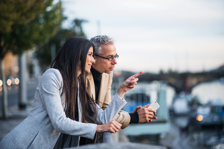 Man and woman business partners standing by a river in city of Prague.の写真素材