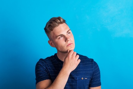 Portrait of a serious thoughtful young man in a studio standing in a studio.