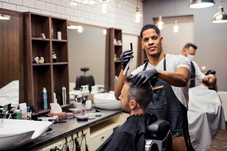 A man client visiting haidresser and hairstylist in barber shop.の写真素材