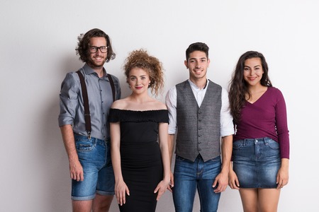 Portrait of young group of friends standing in a studio.の写真素材