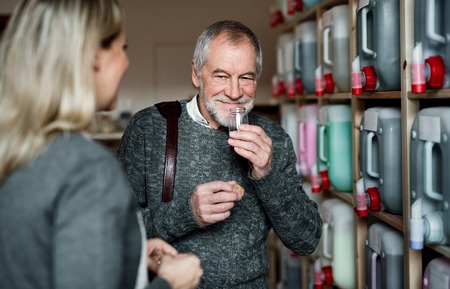 Young female shop assistant serving a senior man in a zero waste shop.の写真素材