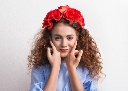A front view of young beautiful woman with red flower headband.の写真素材
