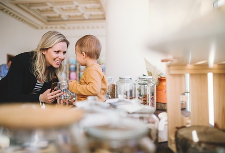 A young woman with a toddler boy buying groceries in zero waste shop.の写真素材