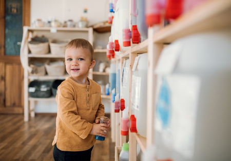 A small toddler boy standing by dispensers in zero waste shop.の写真素材