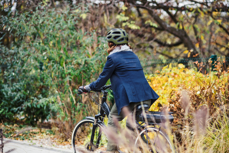 Unrecognizable active senior woman with electrobike cycling outdoors in park.の写真素材