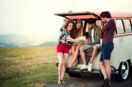 A group of young friends on a roadtrip through countryside, looking at map.の写真素材