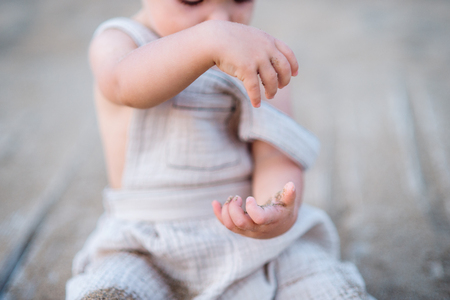 A midsection of small toddler girl sitting on beach on summer holiday, playing.の写真素材
